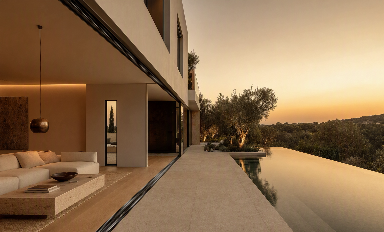 Modern villa with slim-track sliding doors opening onto a courtyard and infinity pool at golden hour